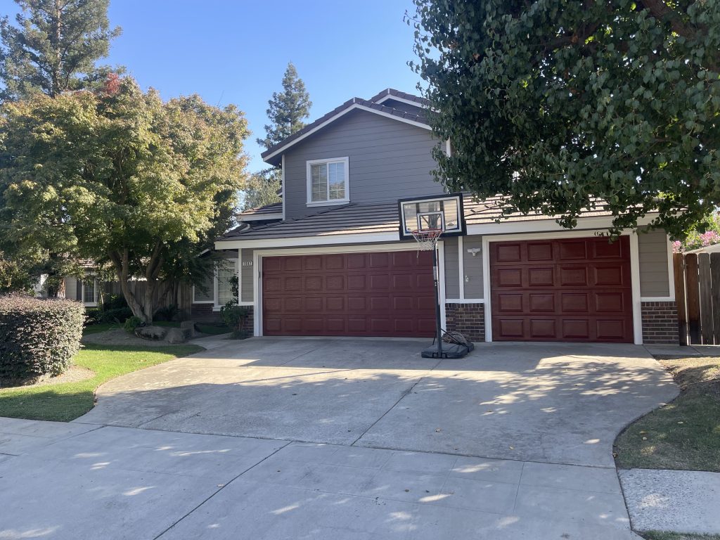 Full house exterior with red garage doors