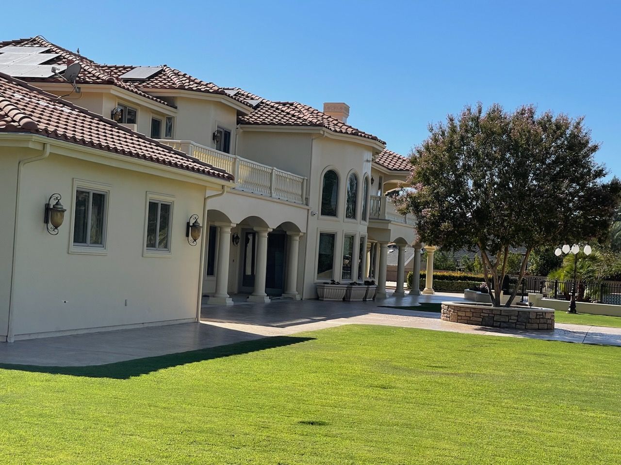 Cream estate with a columned arcade and white balcony rail