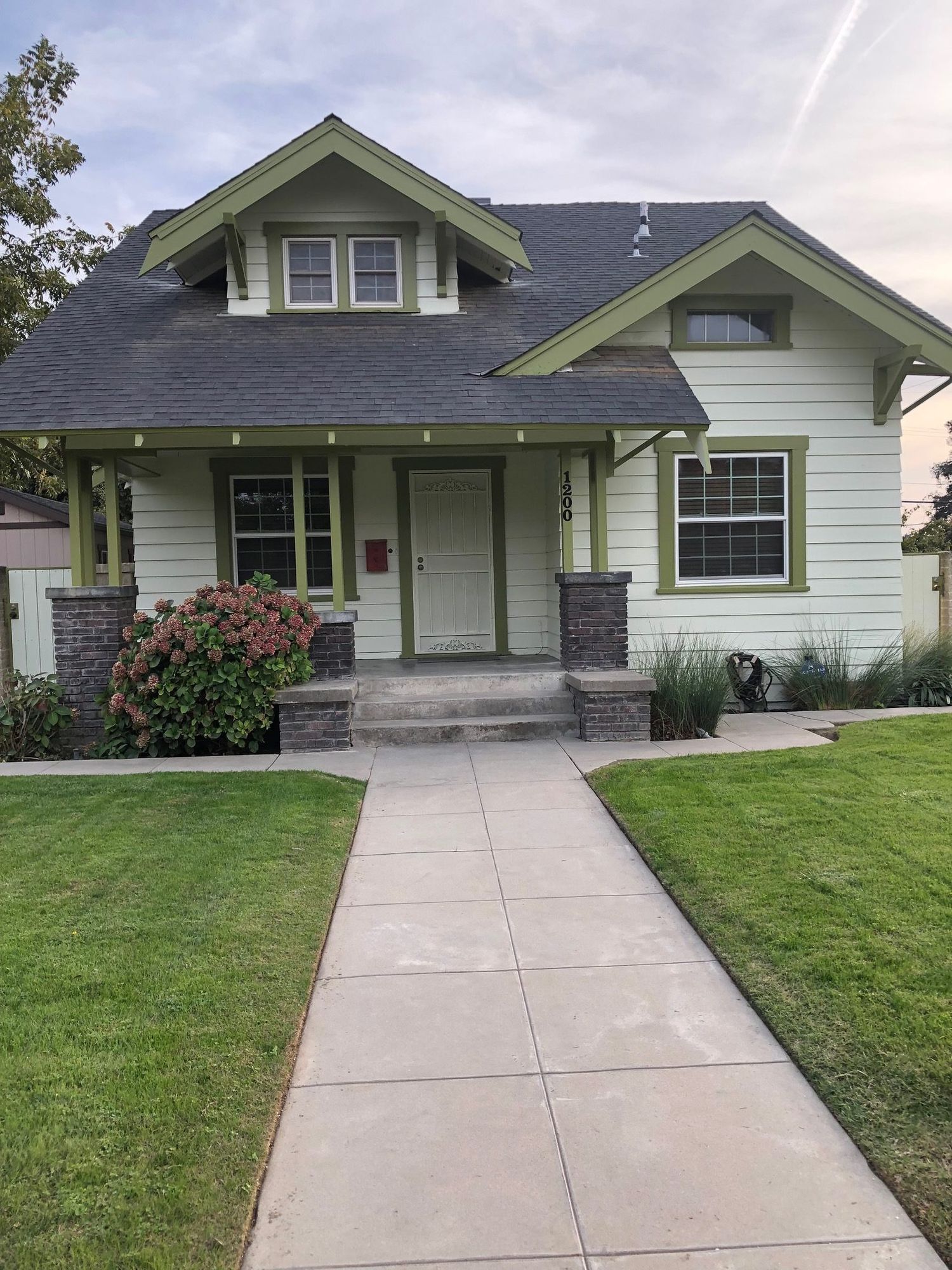 Sage craftsman house with olive trim and a painted front porch