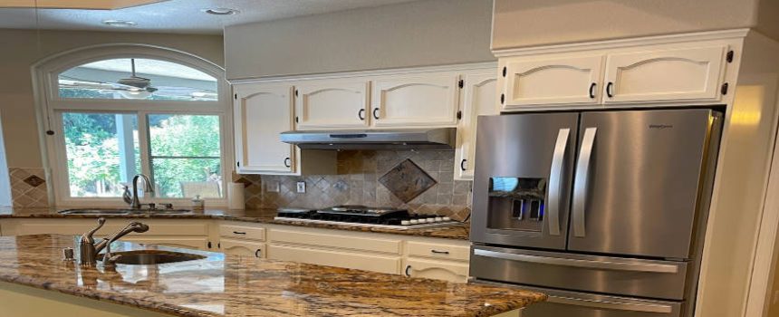 Refinished kitchen cabinets in Woodward Park, Fresno, by Liberty Painting & Decorating Inc., showcasing a sleek, modern finish.